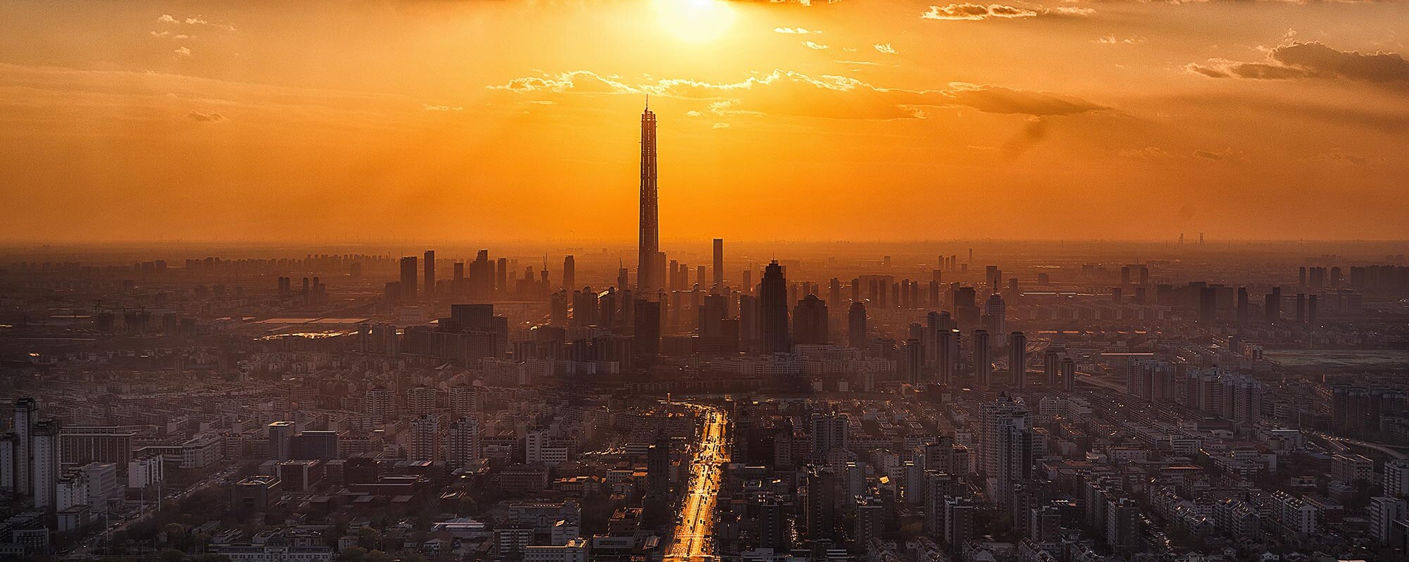 Picture of City Skyline With Sun in Background